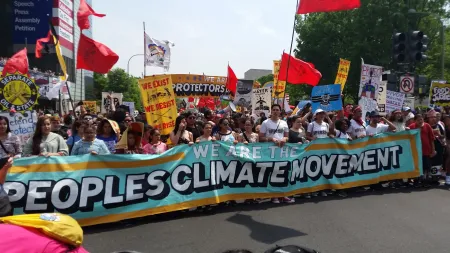 Photo of people on street carrying banner that says “People's Climate Movement”
